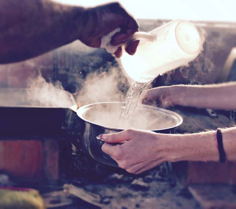 hot water being poured into a bowl for breaking-in tight soccer cleats