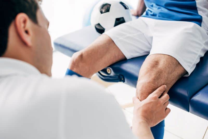 Physio massages the knees of a player but How Often Do Soccer Players Get Massages?