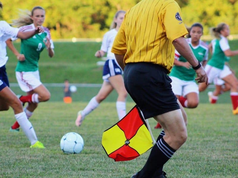 referee officiates a female soccer game