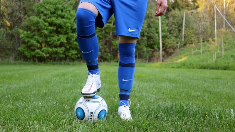 soccer player wearing blue shorts and blue socks with ball at his feet but Are Soccer and Baseball Socks The Same?
