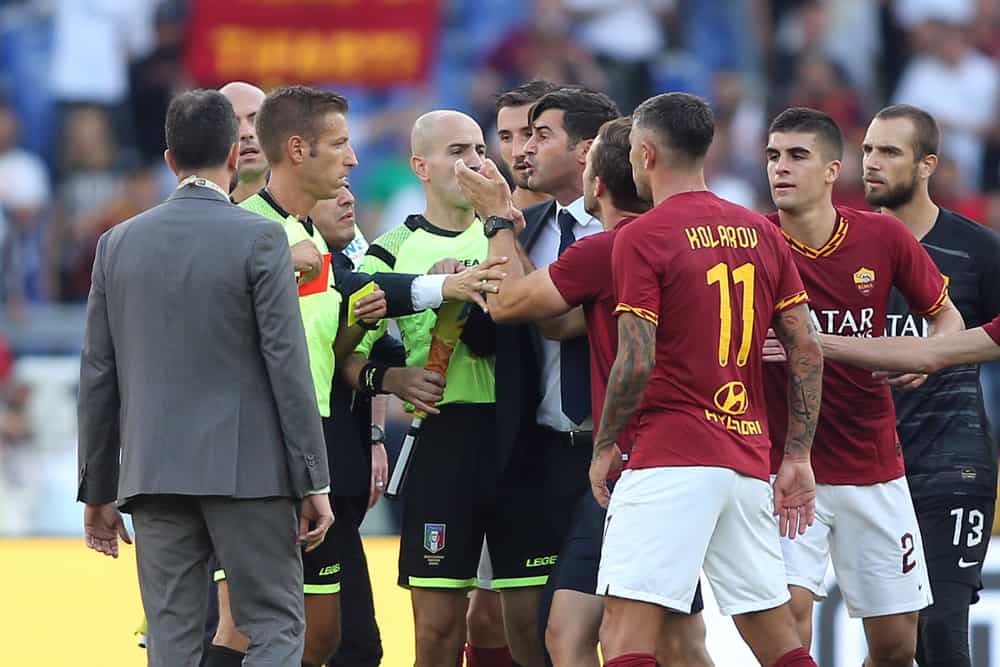 players confront a referee on the field.